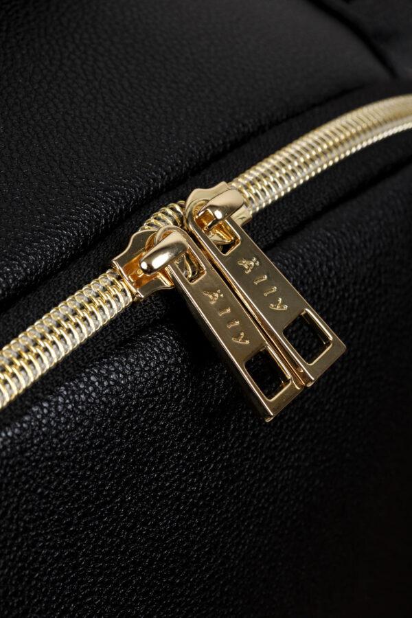 Close-up of gold zipper on black diaper backpack for small babies.