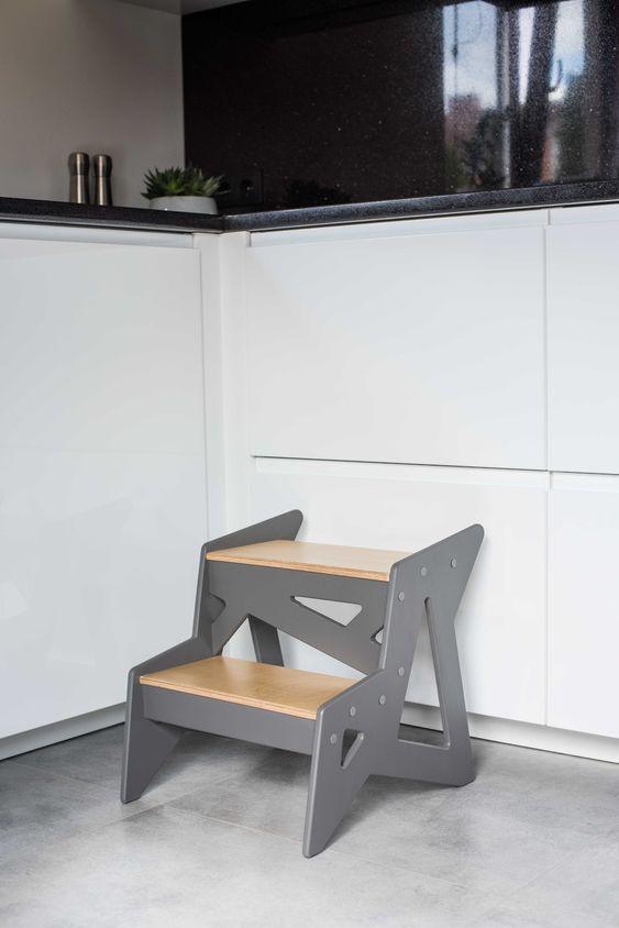 Modern wooden step stool with gray and natural wood finish in kitchen.