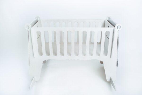 White baby cradle with safety rails and sturdy construction.