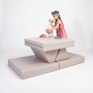 Kinder spielen auf beige Aktivitäts-Spielmatratzen-Set mit Spielzeug und Brille.