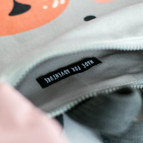 Close-up of a kids backpack with a Bunny design and a 'Made for Adventure' label inside.