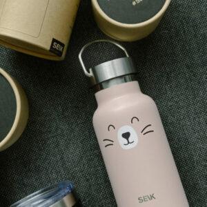 Cute cat-themed stainless steel water bottle with SEIK logo on dark fabric background.