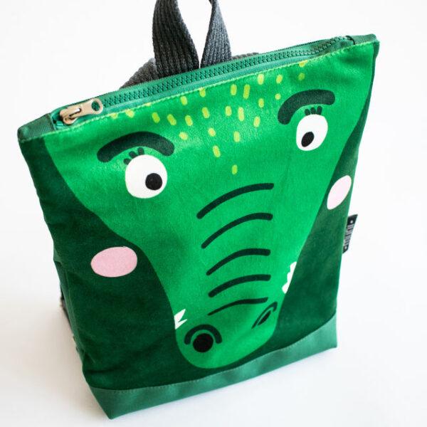 Kids backpack with a crocodile face design, green color, and playful features.