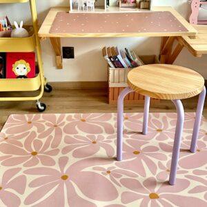 Kinderzimmer mit Spiel- und Lernbereich, pinke und lila Akzente.
