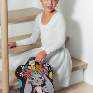 Young girl with a bunny-themed backpack sitting on stairs at home.