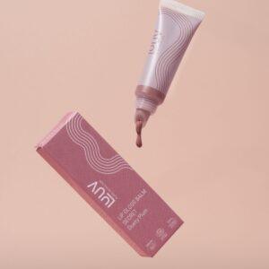 Lipgloss-Balsam in zartem Rosa, auf einer neutralen Oberfläche.