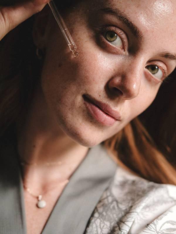 Frau mit Pipette bei Hautpflegeanwendung, Anti-Aging Serum.