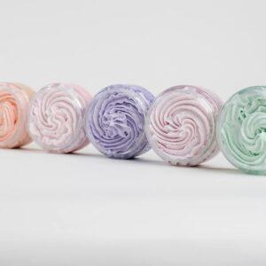 Bunte, spiralförmige Körperpeelings in Pastellfarben.