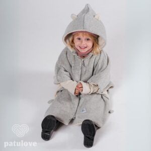 Kleines Kind in einem grauen Kinder-Poncho mit Tierohren.