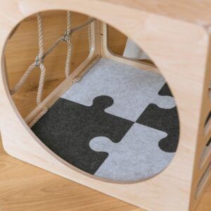 Colorful felt puzzle playmat with climbing toy structure for kids.