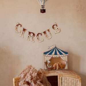 Wooden circus-themed wall decor with hot air balloon and tent illustrations.