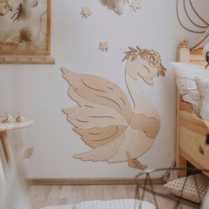 Wooden swan wall decoration in a cozy bedroom setting.